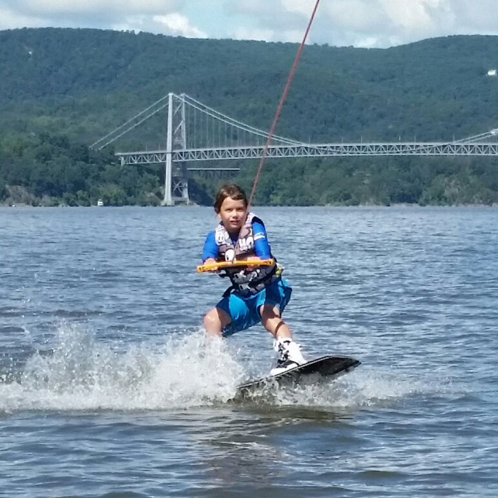 Boy wakeboarding behind a boat